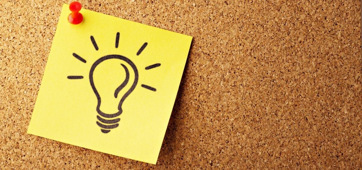 light bulb on sticky note on bulletin board