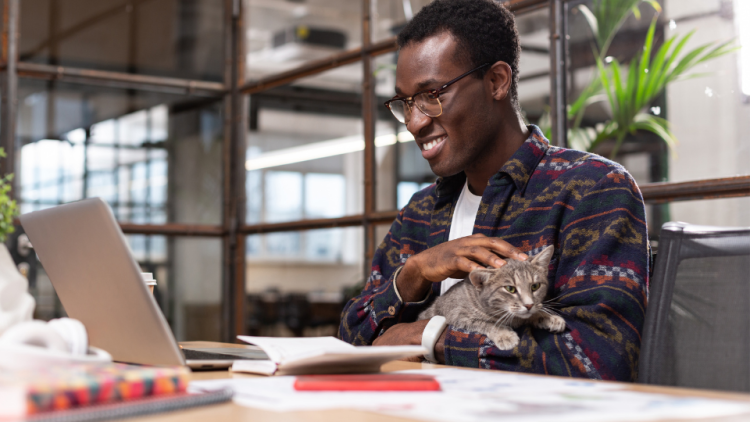 man holding kitten while working